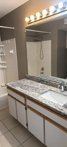 a bathroom with a granite countertop sink and mirror