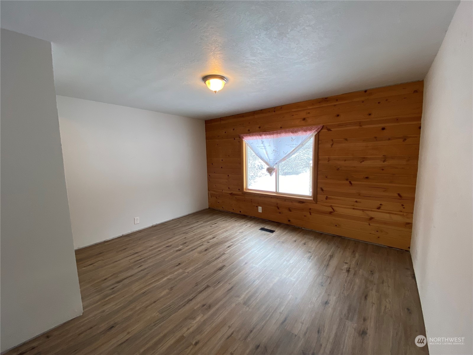114 Twisp River Road Twisp, WA 98856 - Photo 23 of 35 an empty room with wooden floor and windows