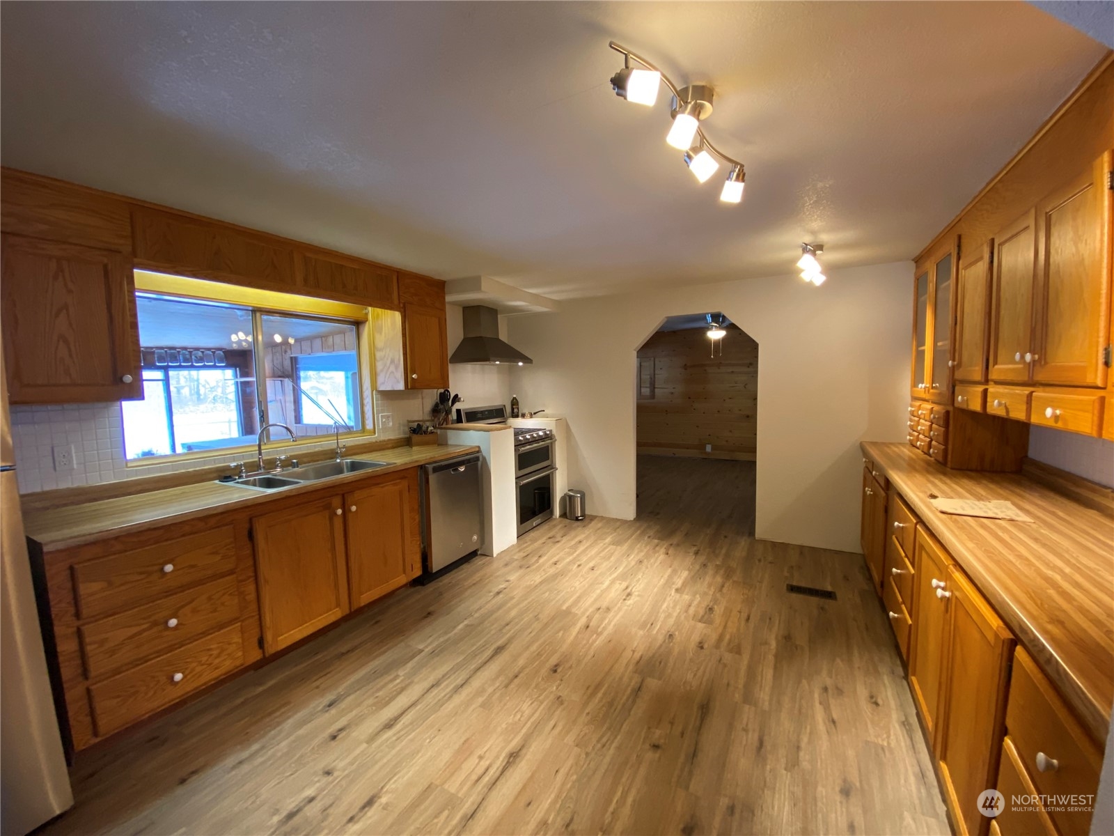 114 Twisp River Road Twisp, WA 98856 - Photo 10 of 35 a kitchen with stainless steel appliances granite countertop a stove a sink dishwasher and a refrigerator with wooden floor