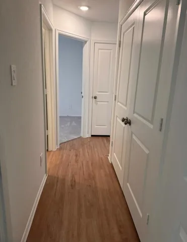 a view of a hallway with wooden floor