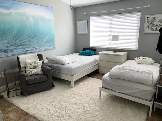 a bedroom with two beds and a window