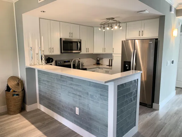a kitchen with stainless steel appliances a refrigerator sink and stove