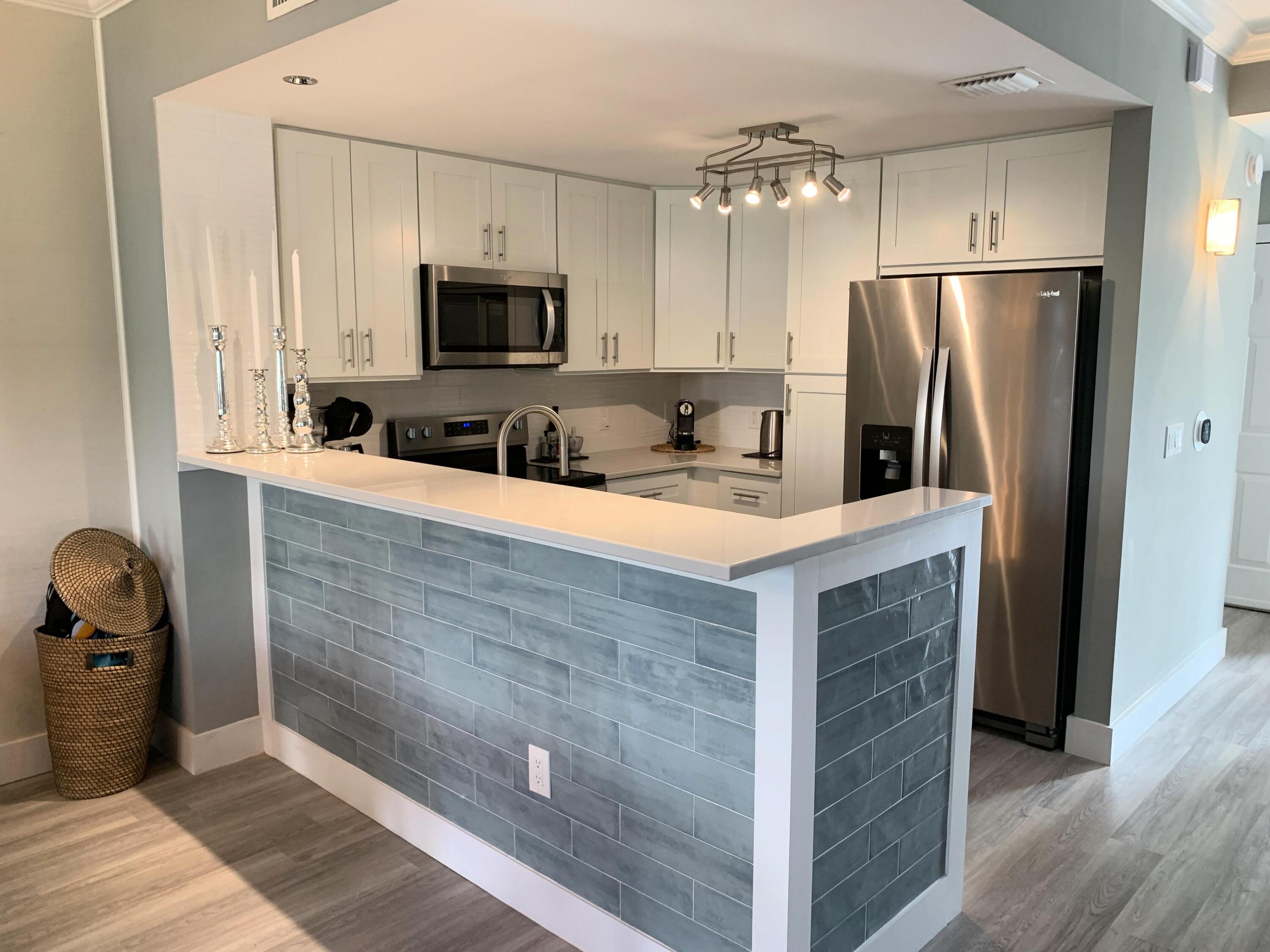3604 South Ocean Boulevard, Unit 101 Highland Beach, FL 33487 - Photo 4 of 36 a kitchen with stainless steel appliances a refrigerator sink and stove