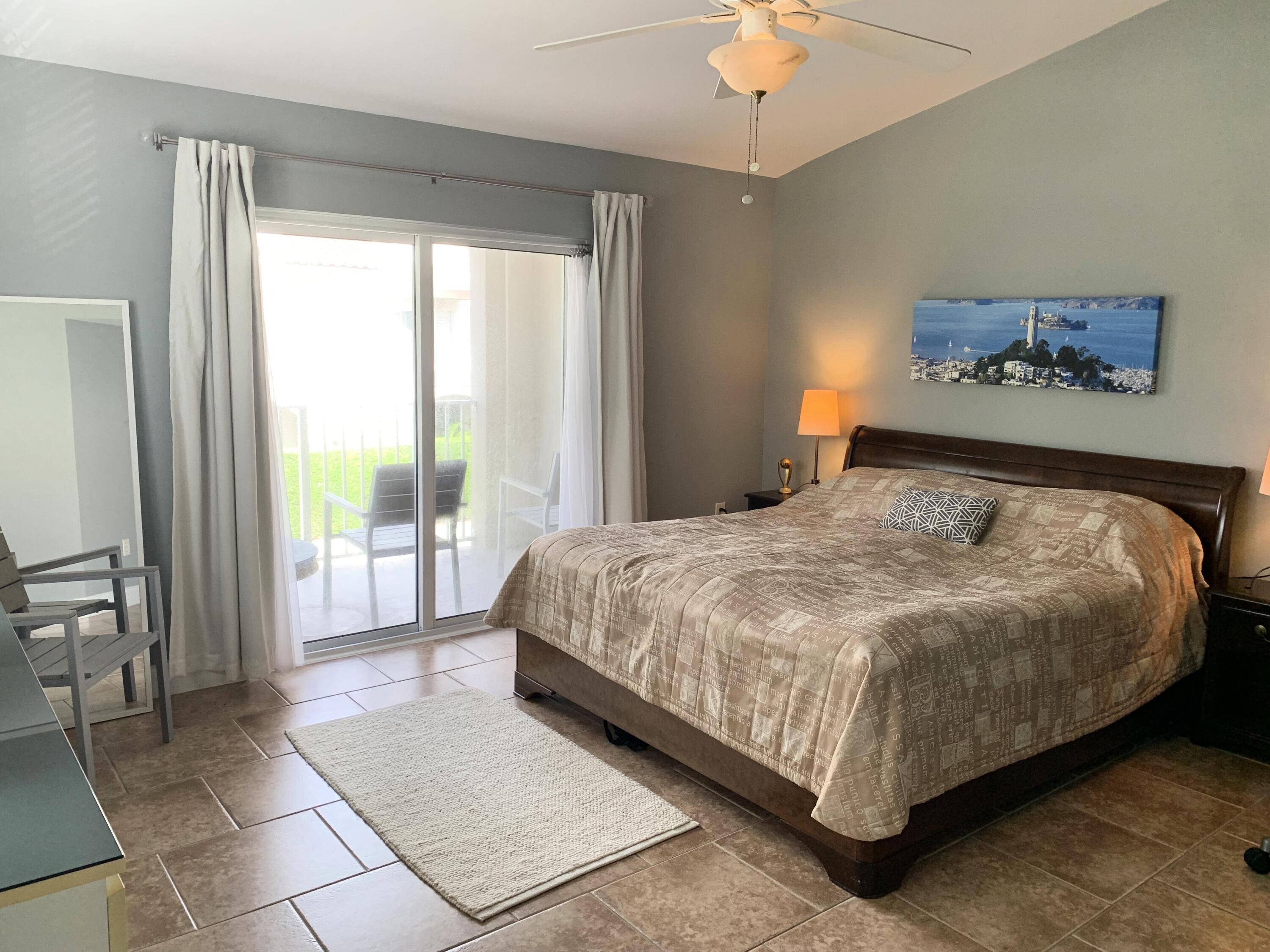 3604 South Ocean Boulevard, Unit 101 Highland Beach, FL 33487 - Photo 9 of 36 a bedroom with a bed and a chandelier