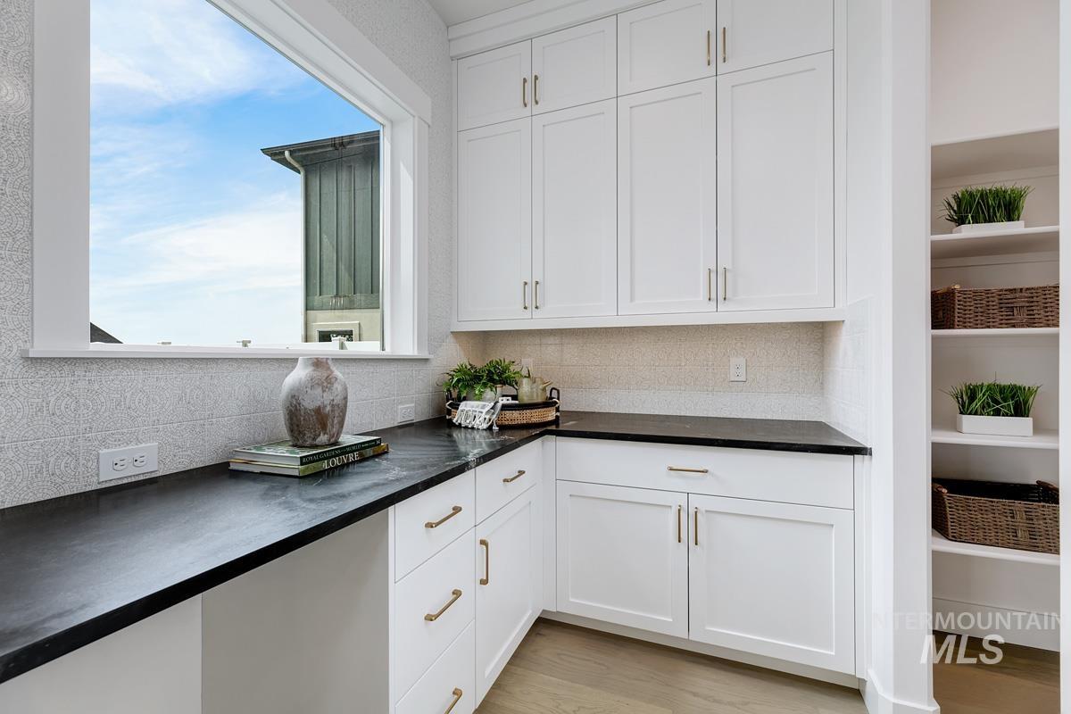 13339 North Hazel Grouse Way Boise, ID 83714 - Photo 16 of 50 Kitchen featuring white cabinets, light wood-type flooring, and decorative backsplash