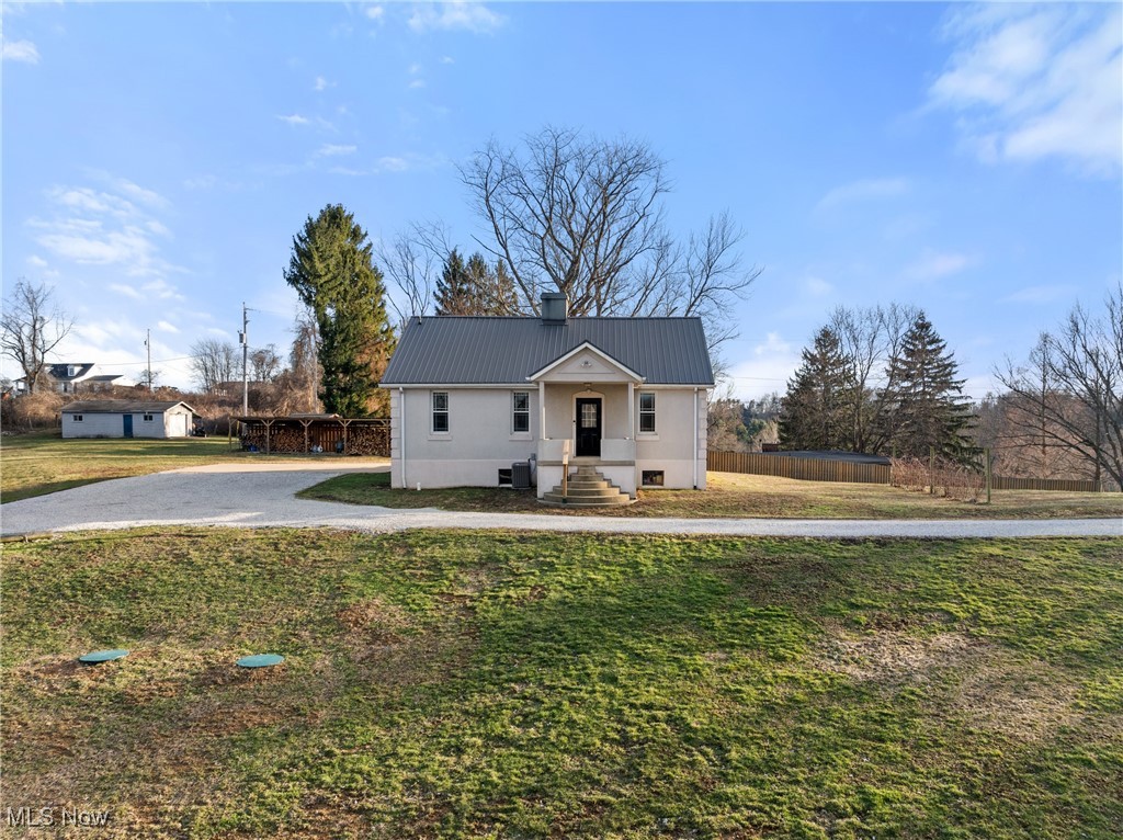 71963 W Road Martins Ferry, OH 43935 - Photo 38 of 39 View of front of house with metal roof, a front lawn, a chimney, and fence