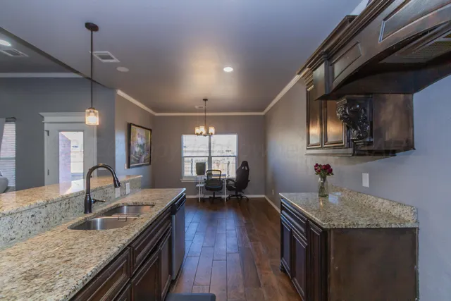 a kitchen with granite countertop a sink stove and cabinets