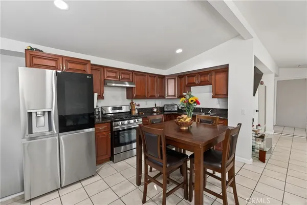 a kitchen with stainless steel appliances granite countertop a refrigerator and a stove top oven