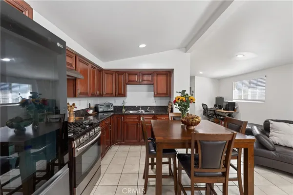 a kitchen with stainless steel appliances a table and chairs in it