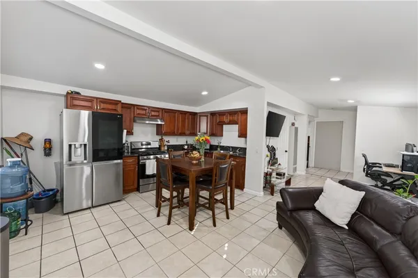 a living room with furniture and a dining table with kitchen view