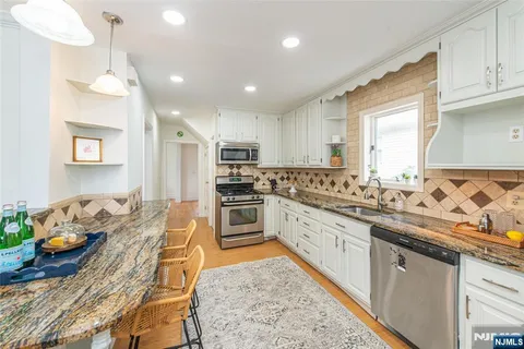 a kitchen with granite countertop lots of counter top space and stainless steel appliances
