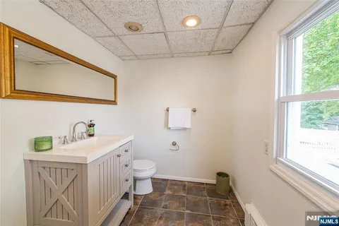 a bathroom with a sink a toilet and a window
