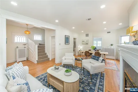 a living room with furniture a rug and kitchen view