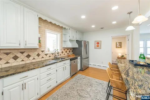 a kitchen with granite countertop cabinets and chairs