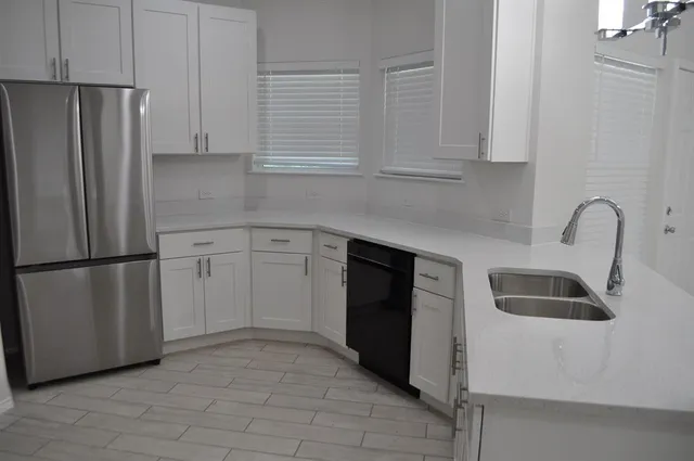 a kitchen with white cabinets and sink