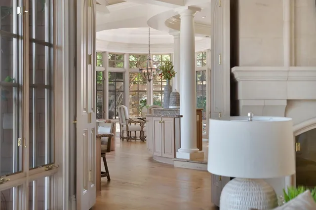 a living room with furniture floor to ceiling windows and wooden floor