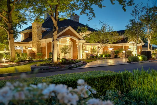 a view of a house with a yard and large tree
