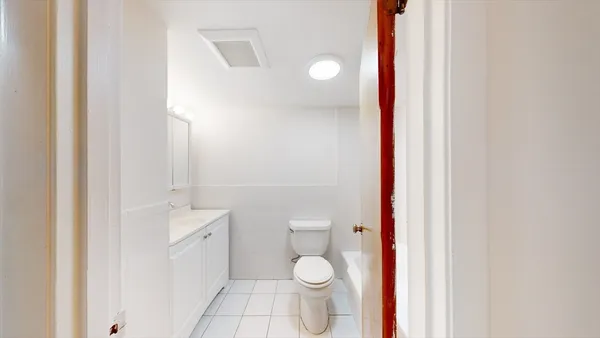 a bathroom with a toilet a sink and shower curtain