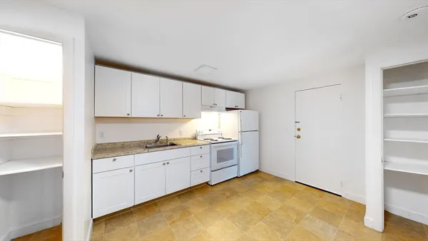 a kitchen with granite countertop a sink and cabinets