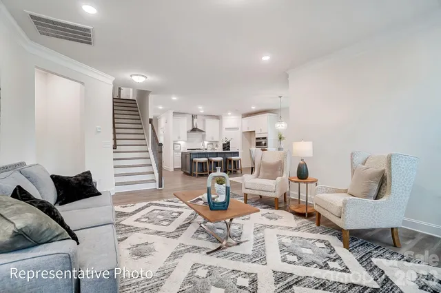 a living room with furniture and kitchen view