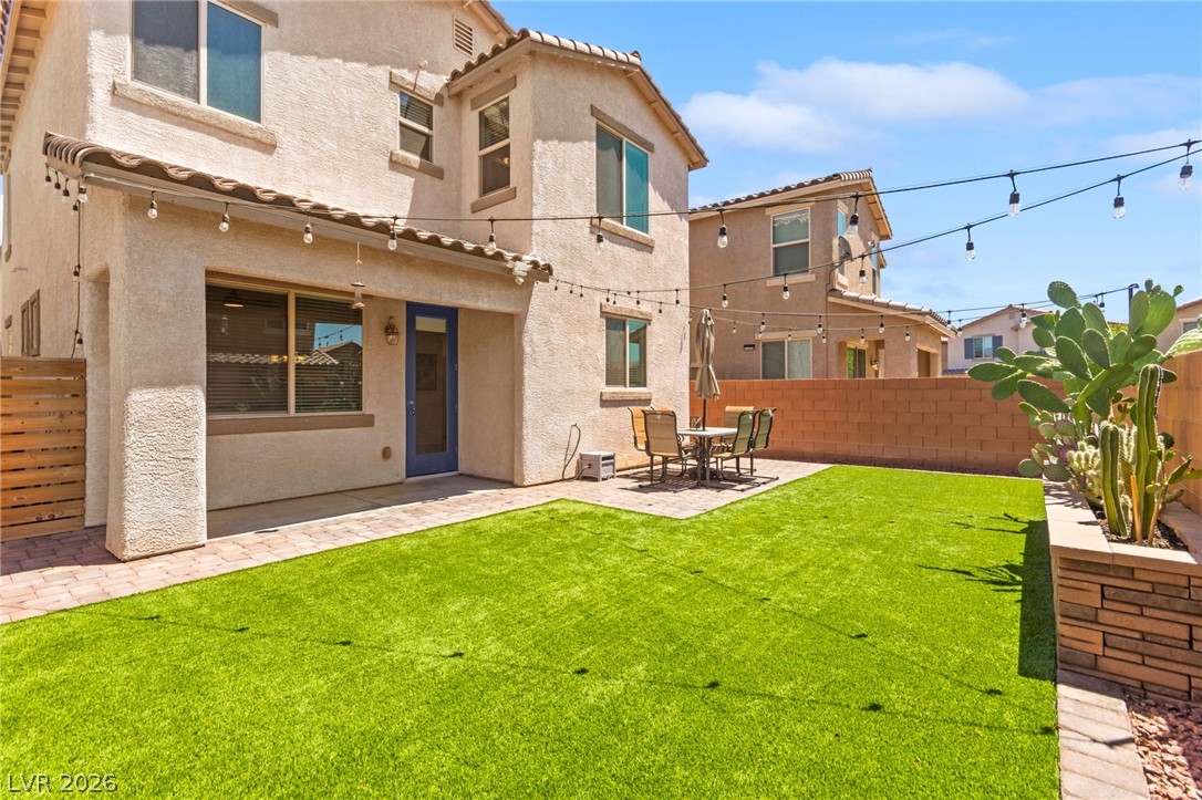 6435 Point Isabel Way Las Vegas, NV 89122 - Photo 1 of 57 A well-maintained yard featuring artificial turf and a patio area, perfect for outdoor enjoyment.