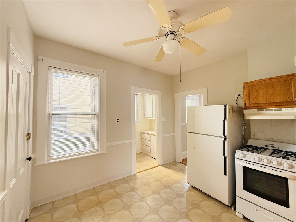 35 Kingston Street, Unit 1 Somerville, MA 02144 - Photo 4 of 8 a kitchen with a refrigerator a stove a microwave and cabinets