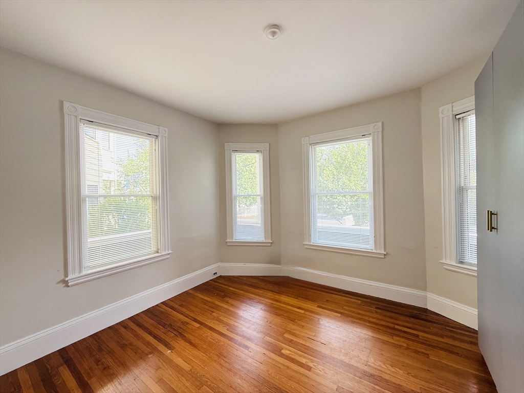 35 Kingston Street, Unit 1 Somerville, MA 02144 - Photo 5 of 8 an empty room with wooden floor and windows