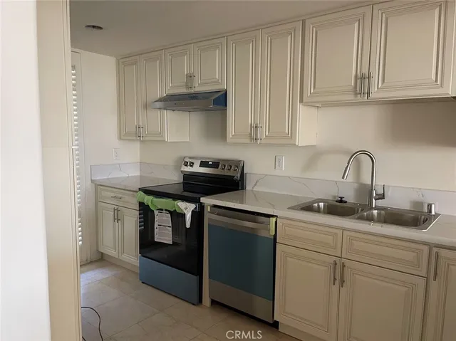 a kitchen with stainless steel appliances granite countertop white cabinets a sink and dishwasher