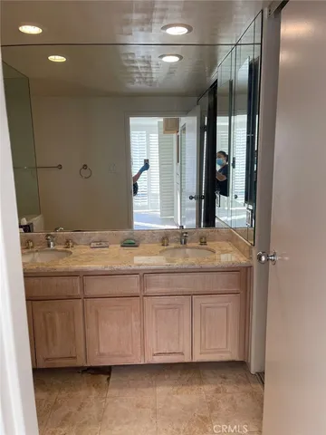 a bathroom with a granite countertop sink a mirror and a shower