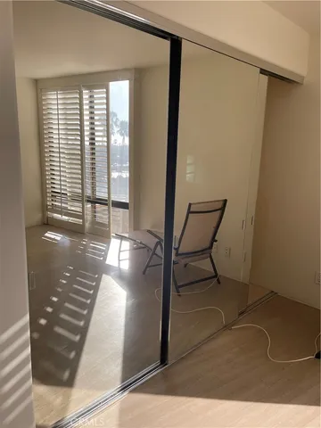 a view of a hallway with wooden floor and dining room