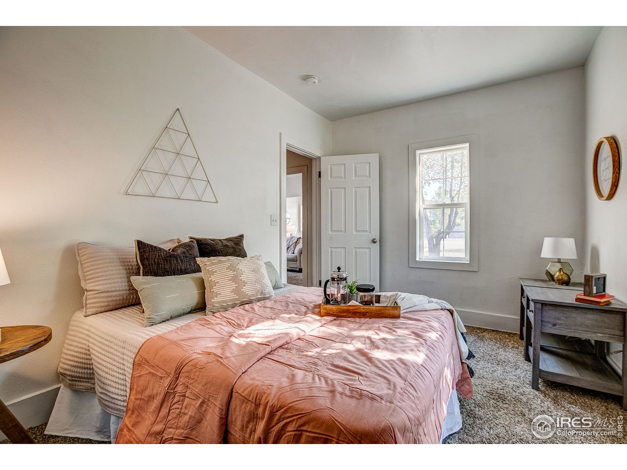26 Main Street Windsor, CO 80550 - Photo 12 of 22 a bedroom with a bed a lamps and a window