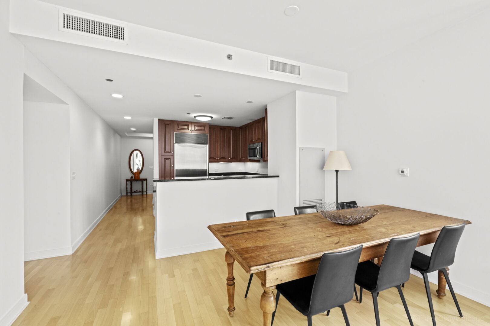 60 East Monroe Street, Unit 1604 Chicago, IL 60603 - Photo 10 of 34 a dinning room with kitchen island a table and chairs in it