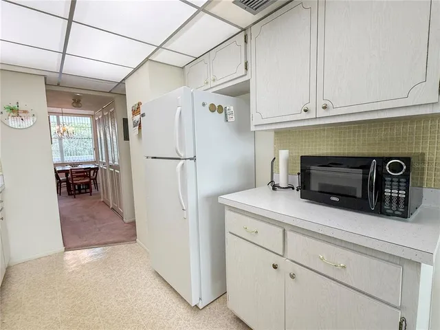 a kitchen with cabinets and a refrigerator