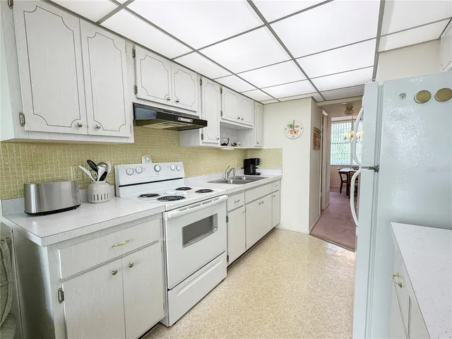 a kitchen with stainless steel appliances granite countertop a sink a stove and cabinets