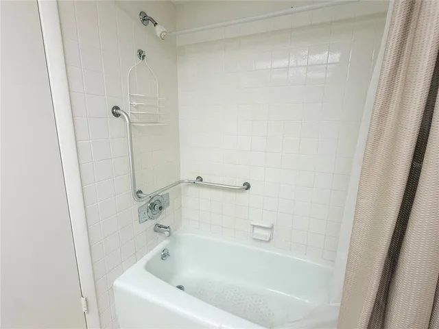 a white bath tub and shower in a bathroom