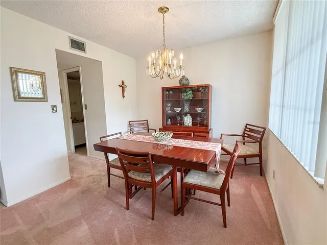 a dining room with furniture a chandelier and wooden floor