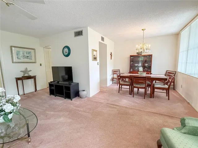 a living room with furniture a dining table and a flat screen tv