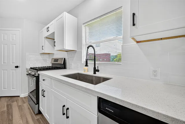 a kitchen with a sink cabinets and appliances