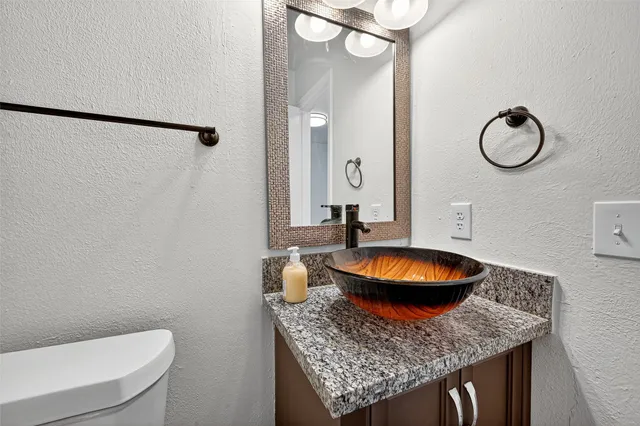 a bathroom with a granite countertop sink and a mirror