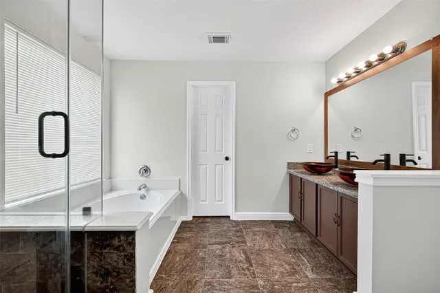 a bathroom with a tub sink and mirror