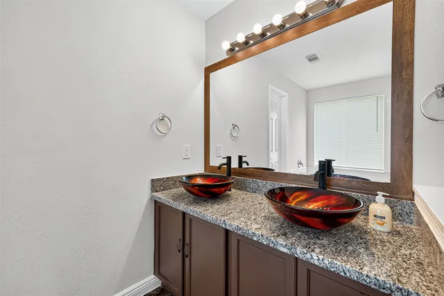 a bathroom with a granite countertop sink and a mirror