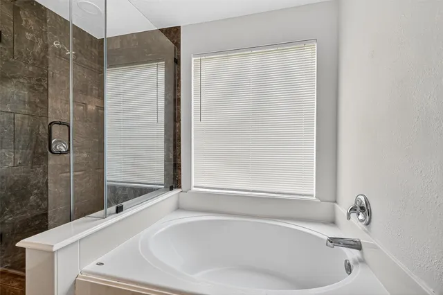 a bathroom with a tub and shower