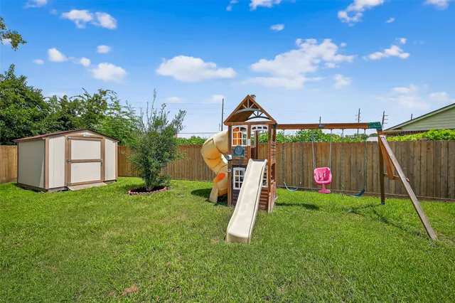 a view of a house with backyard and a tree