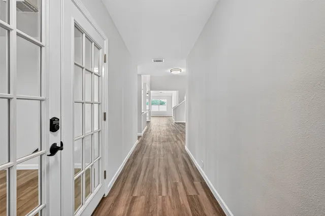 a view of a hallway with wooden floor and closet