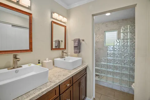 a bathroom with double vanity and a mirror