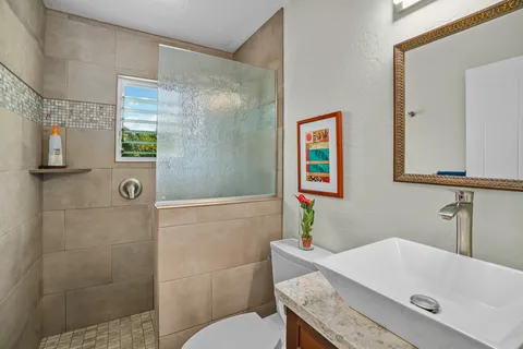a bathroom with a granite countertop bathtub shower sink and toilet