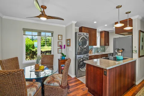 a kitchen with a refrigerator a sink a stove and a dining table with garden view