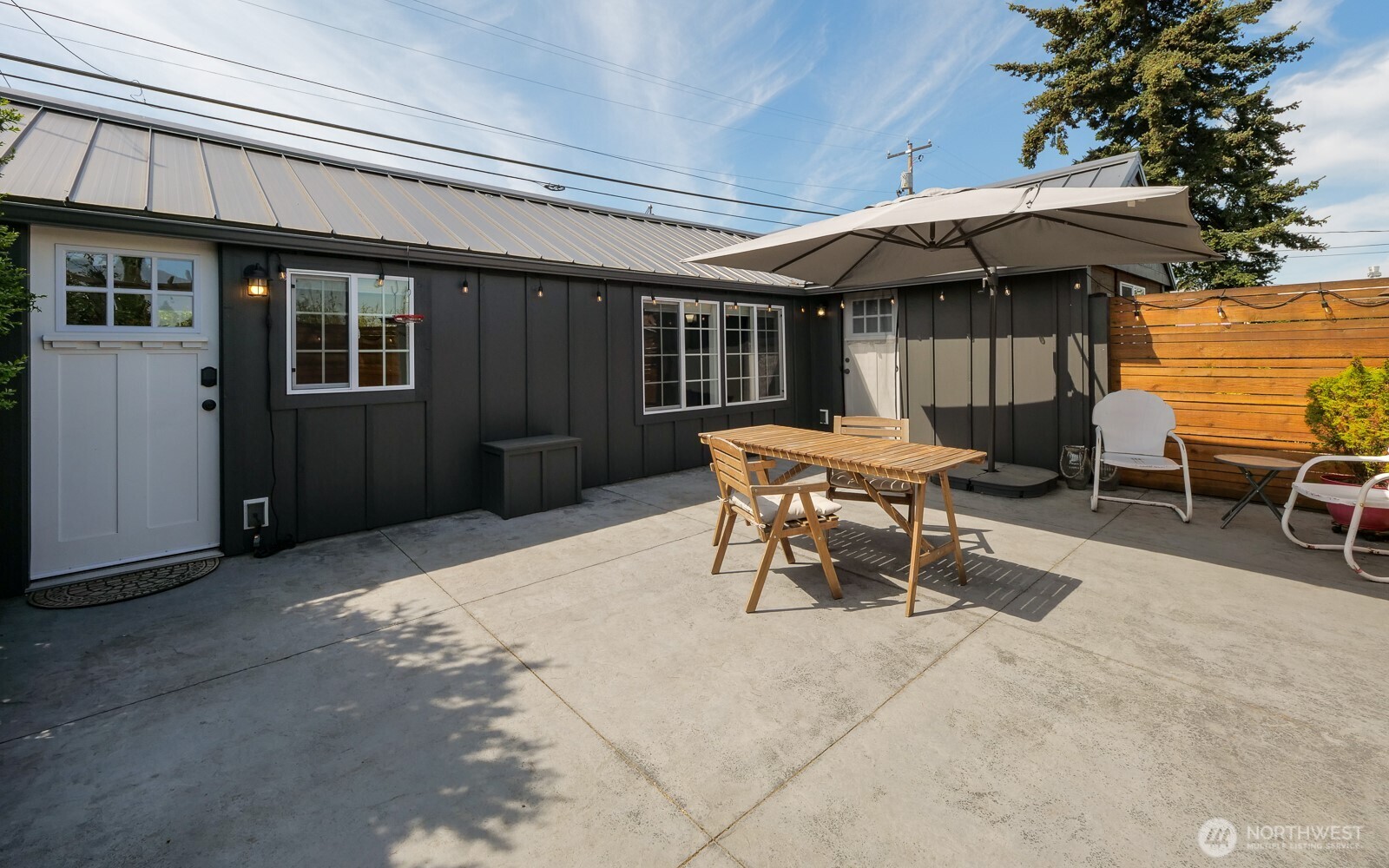 233 West Washington Street Sequim, WA 98382 - Photo 32 of 40 a patio with a table and chairs under an umbrella