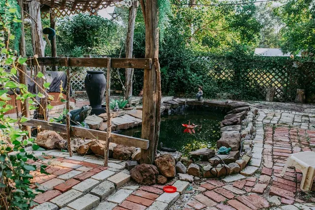 a view of a street with plants and a fountain