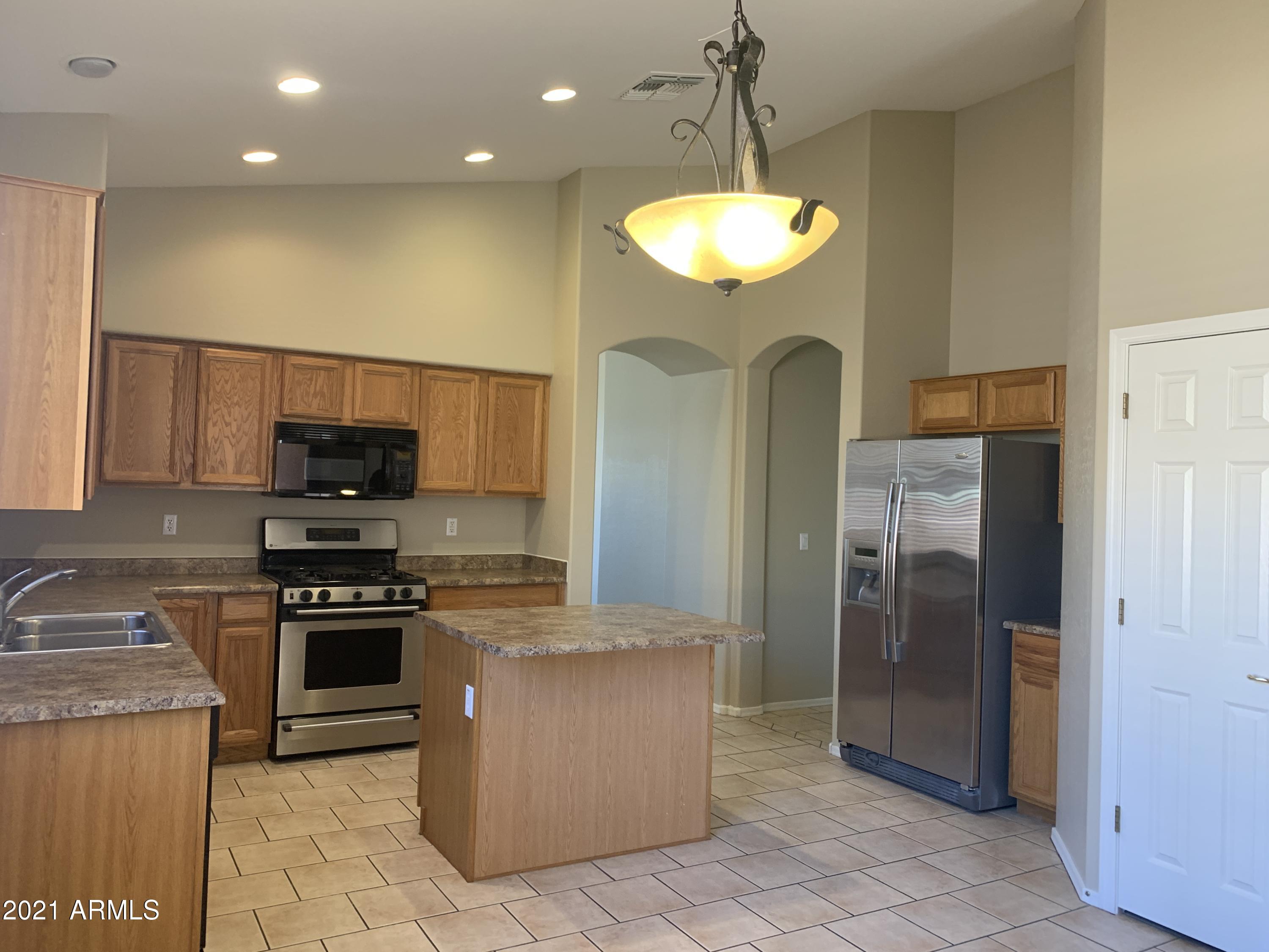 10460 South 182nd Drive Goodyear, AZ 85338 - Photo 16 of 33 a kitchen with stainless steel appliances granite countertop a refrigerator a stove a sink and a oven